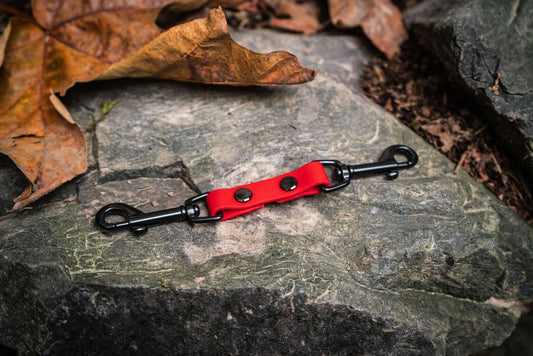 collar safety clip for dog collars in bright red biothane and double black clips on a stone background