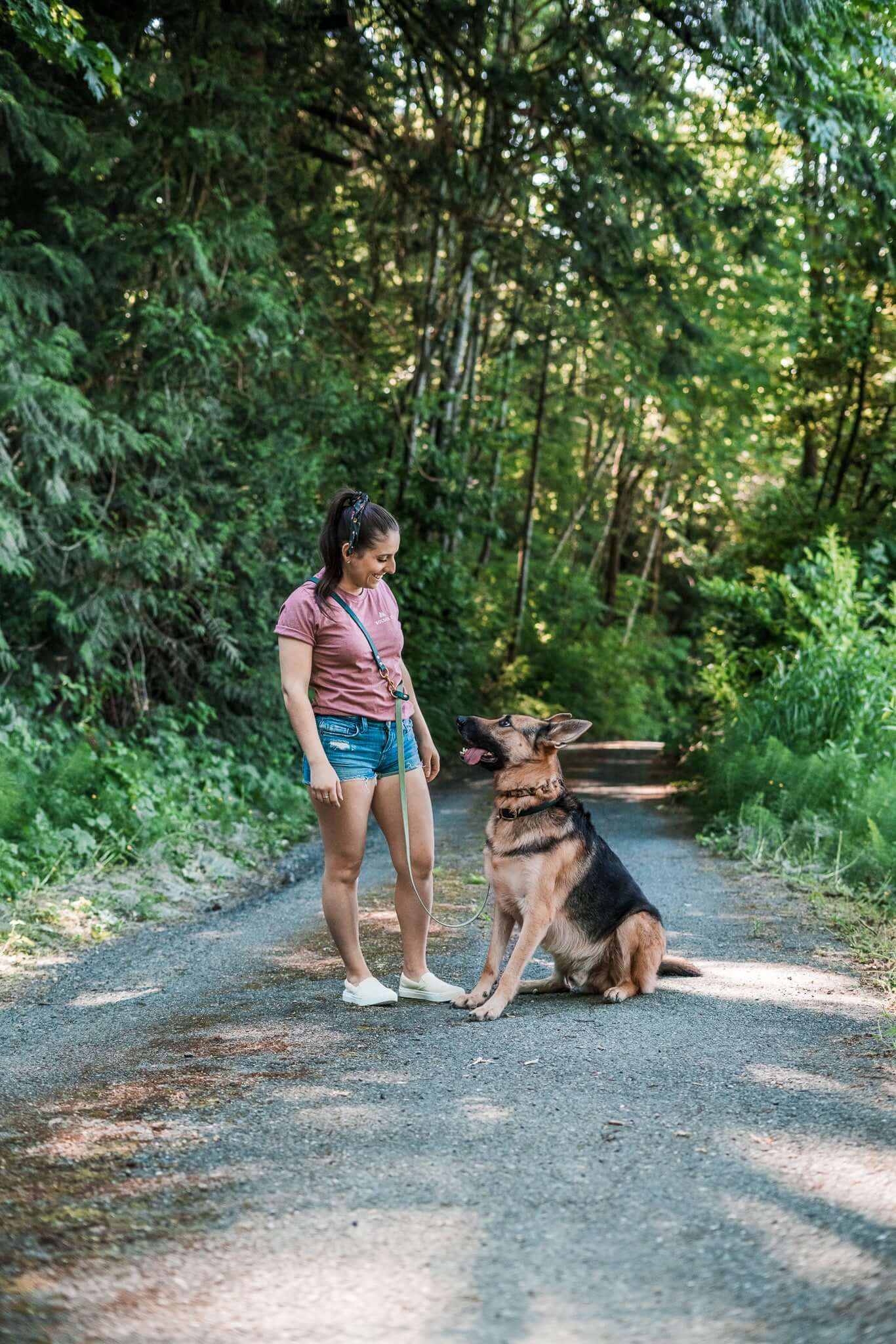 Woman walks dog on forest path using Voyager Hands-Free BioThane® Adjustable Cross-Body Dog Leash