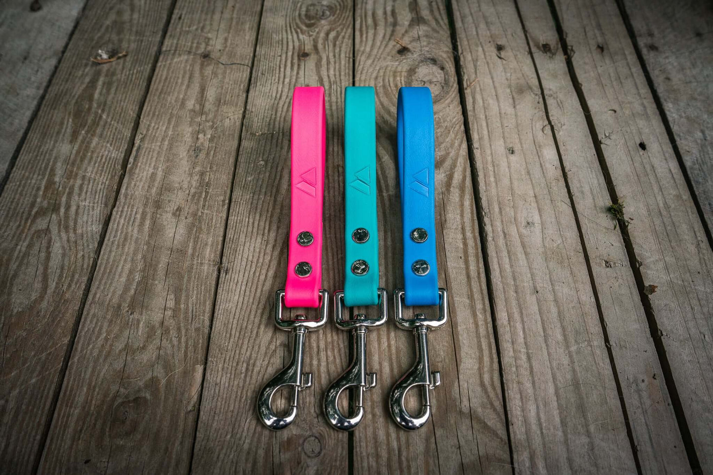 mini dog traffic leads three biothane color handles and silver clips on a wood background