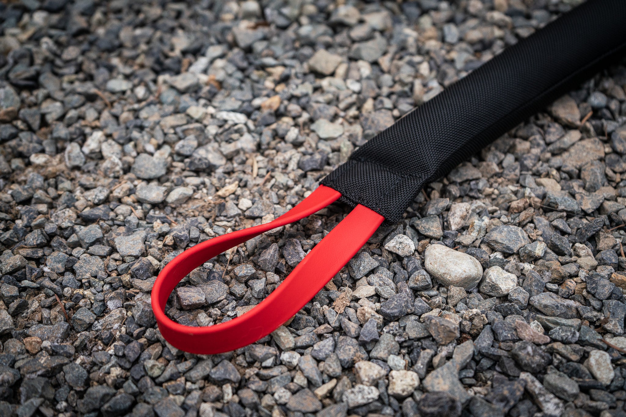 heavy duty bite tug with biothane handles on gravel background